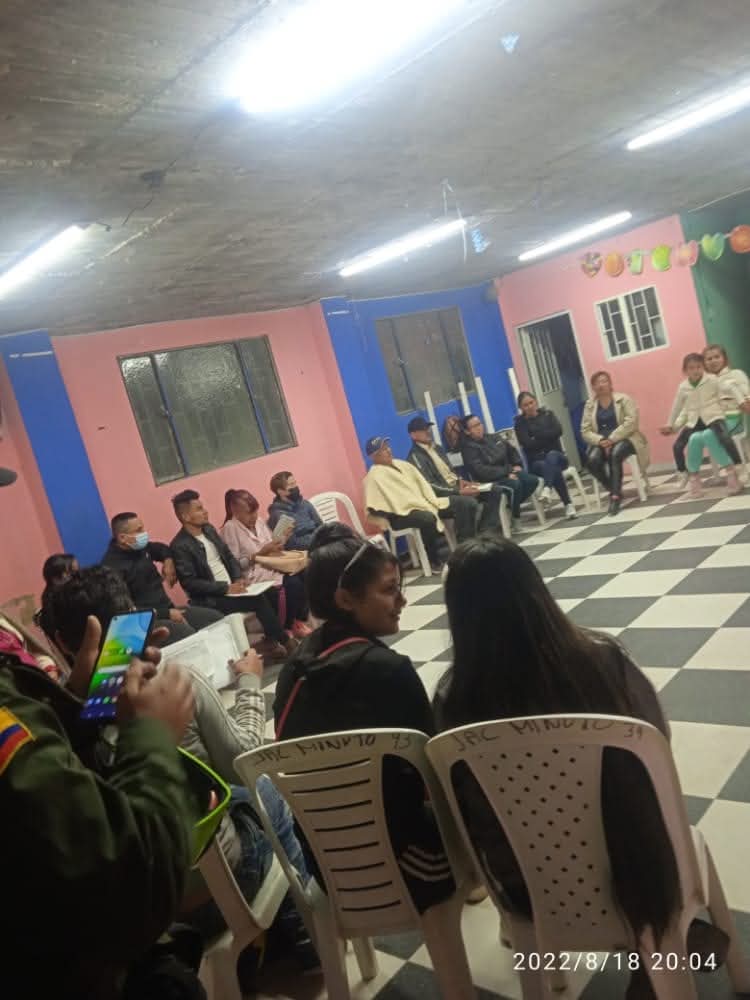 Asamblea comunitaria con asistentes escuchando